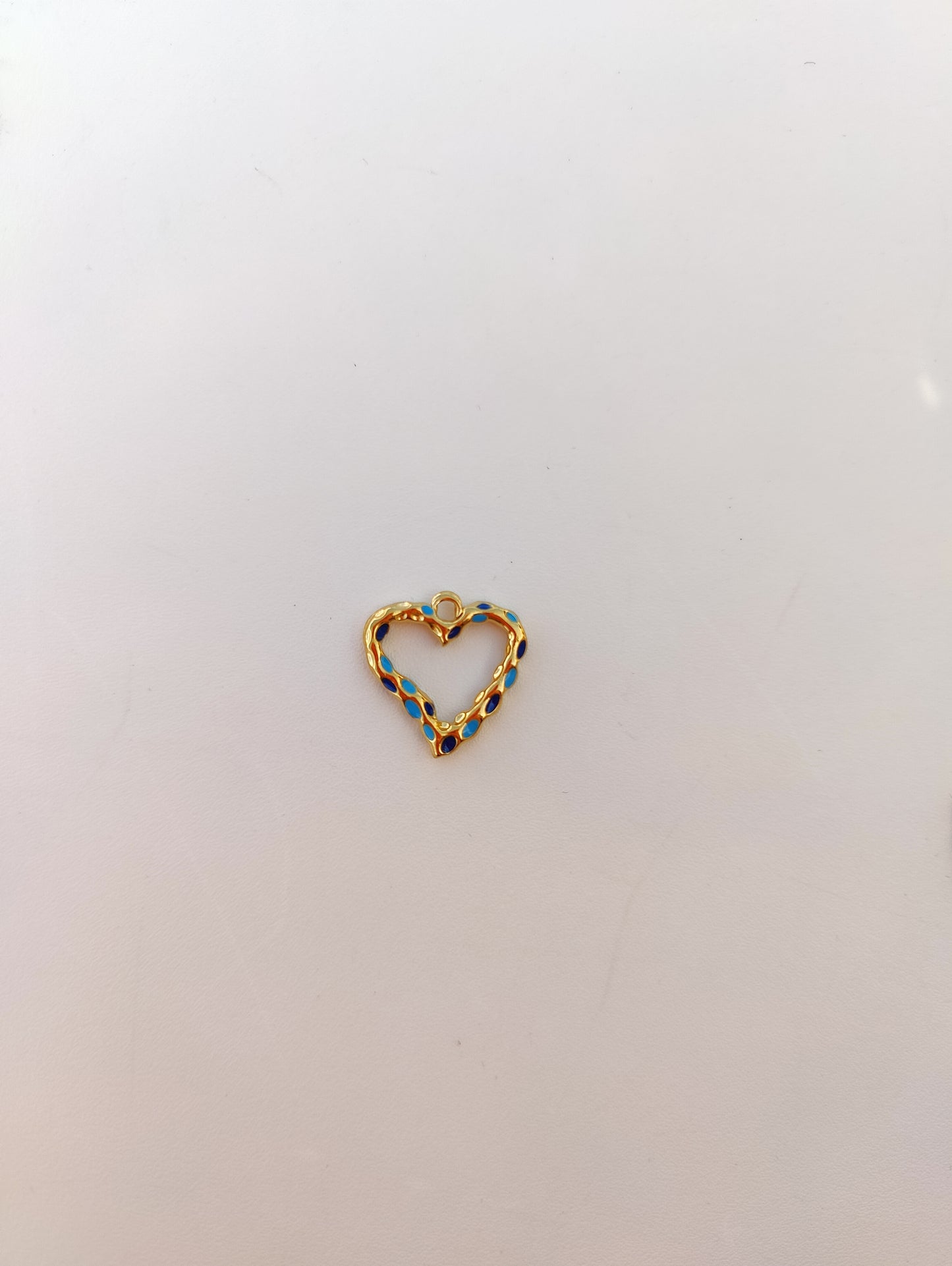 Delicate heart charm in gold and blue, perfect for personalized jewelry and elegant accessories.