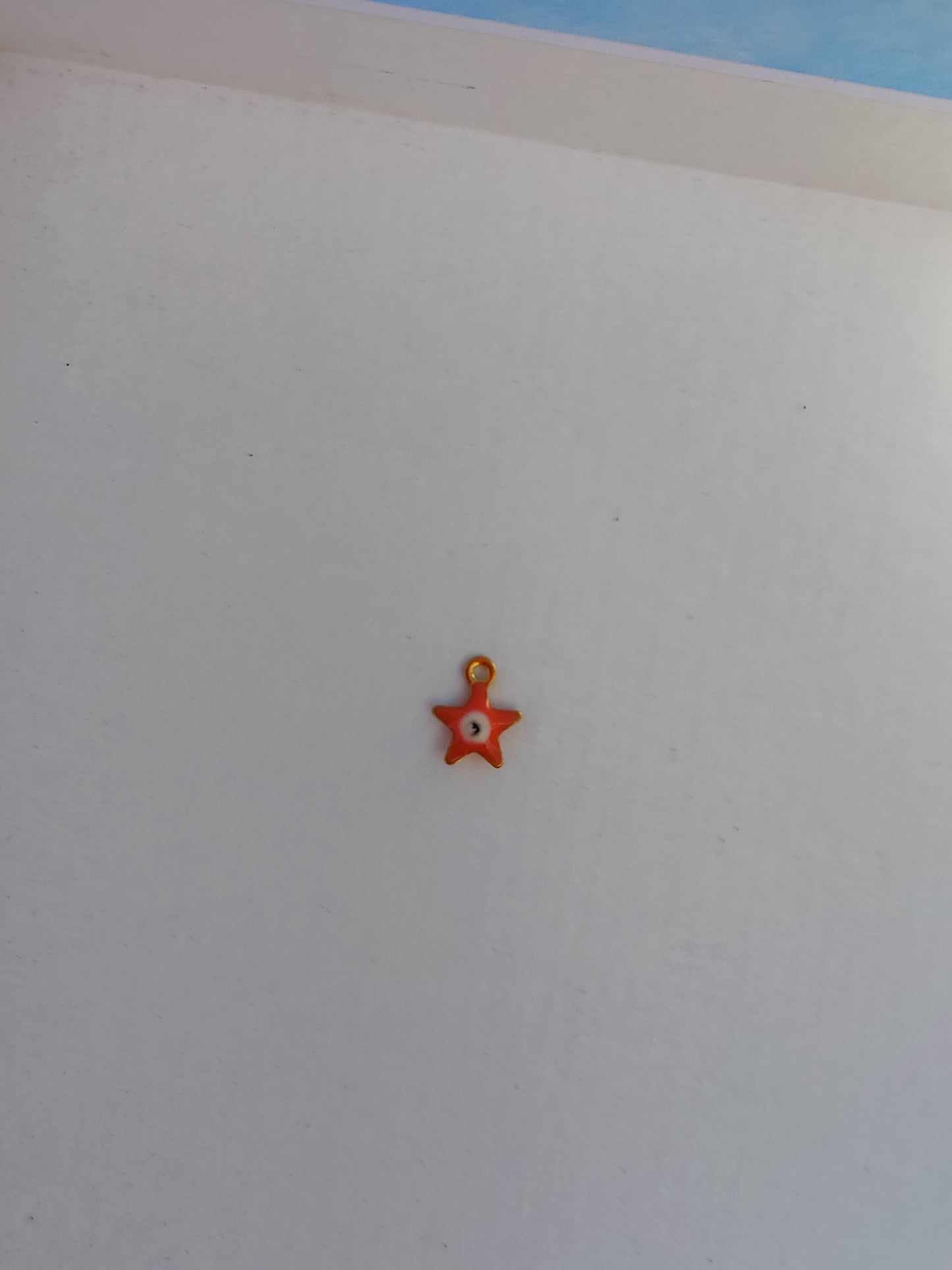 Charm en acier inoxydable en forme d'étoile orange, parfait pour personnaliser vos bijoux.