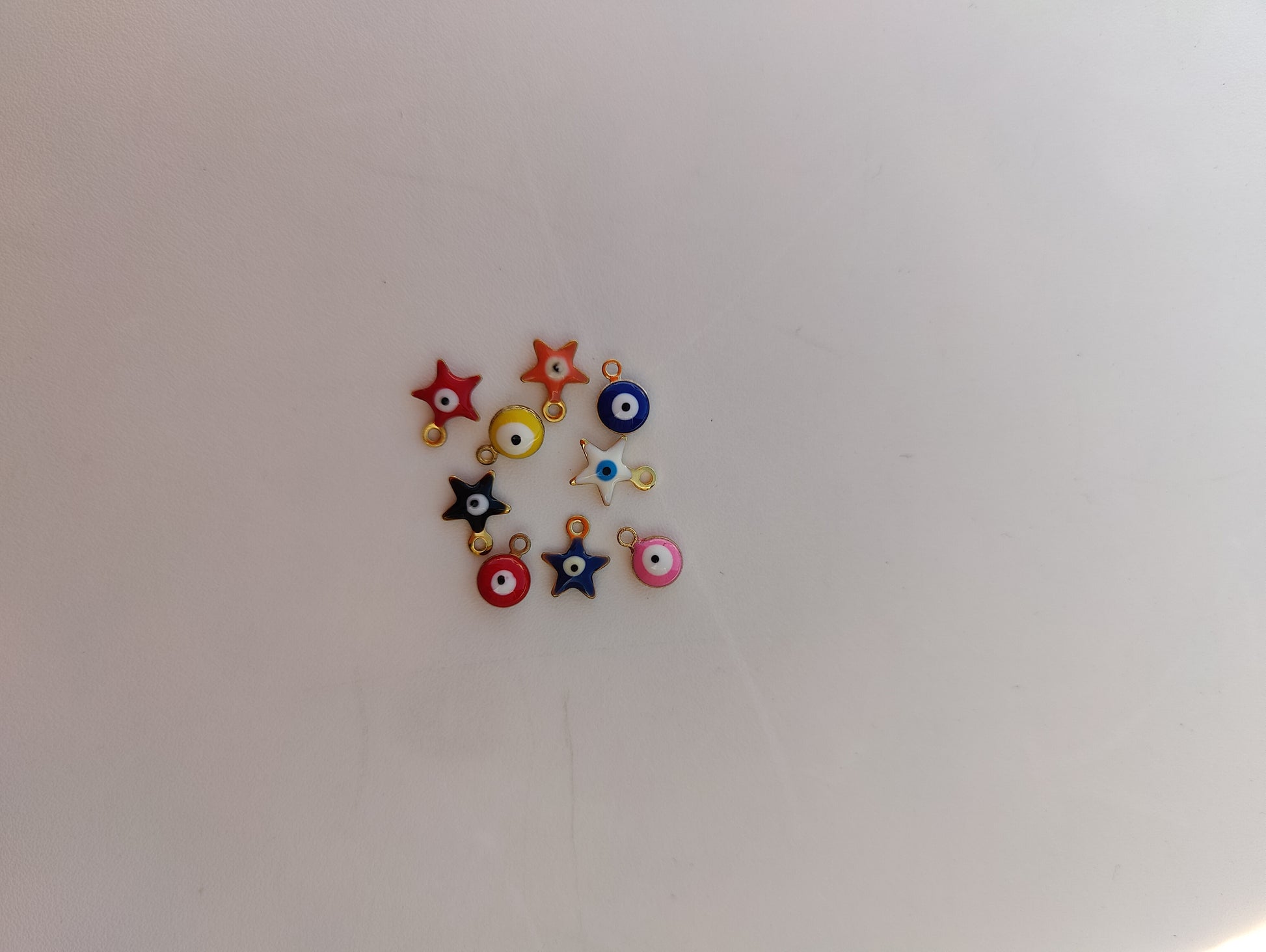 Colorful stainless steel charms for jewelry customization, featuring stars and circular designs.