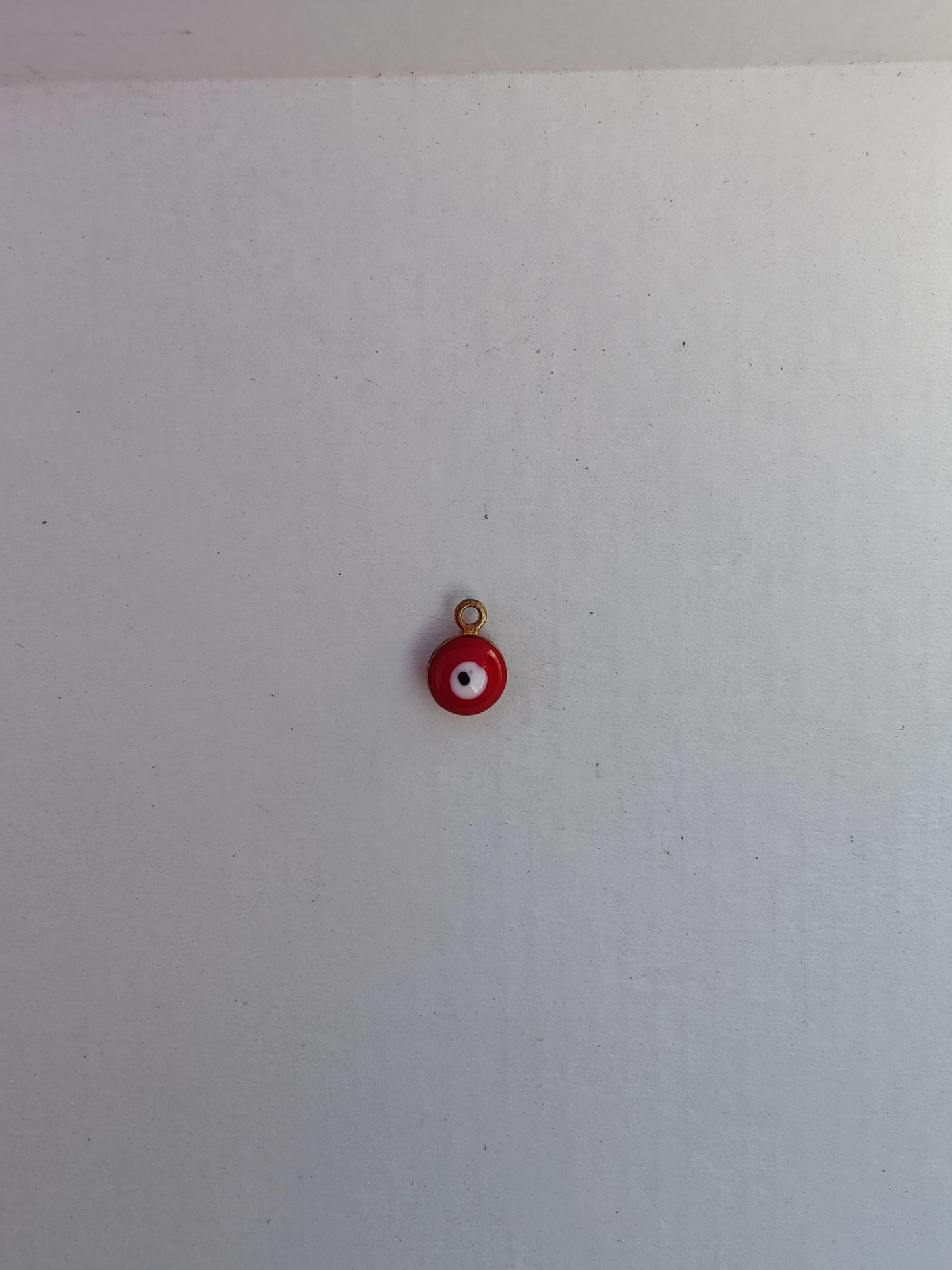 Charm en acier inoxydable rouge avec un œil blanc, idéal pour personnaliser vos bijoux avec élégance.