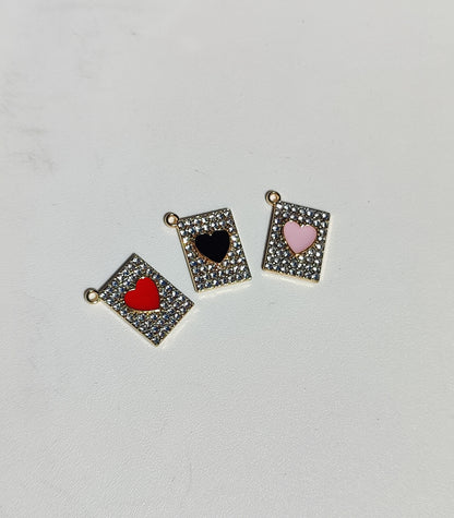 Set of three heart charms in gold frames with red, black, and pink enamel accents for personalized jewelry.