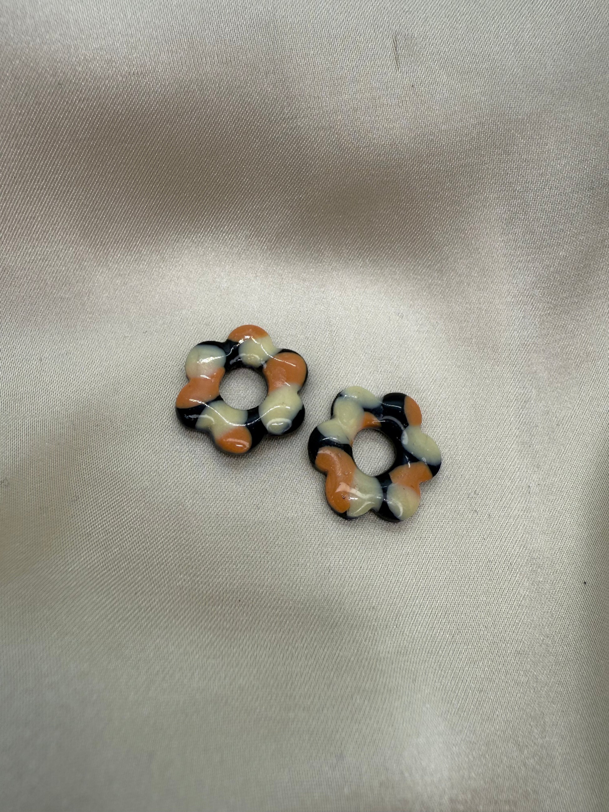boucles d'oreilles personnalisables en formes de fleurs de 2,5cm environ avec cinq branches en pâte polymère, couleur noir à poids orange et beige.
possibilité de nous demander d'autres couleurs.